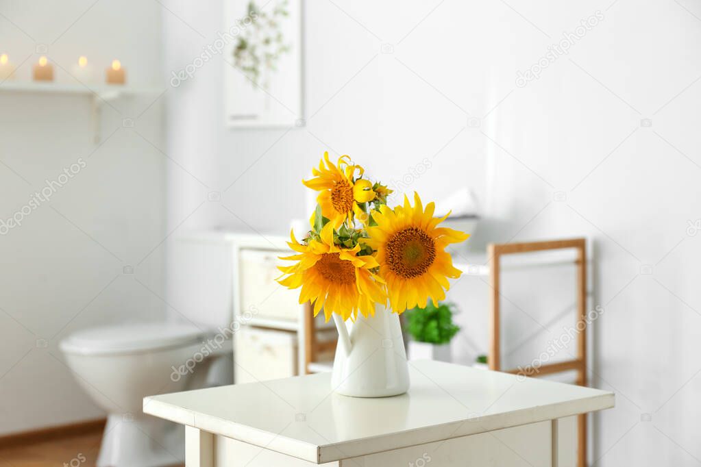 Beautiful sunflower flowers on table in bathroom