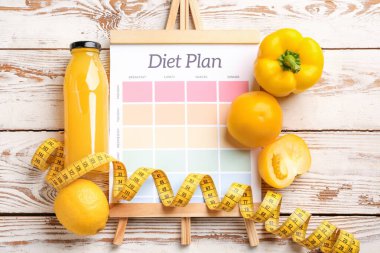 Sheet of paper with diet plan, measuring tape and healthy products on white wooden background