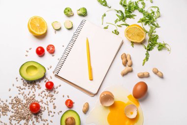 Notebook with healthy products on white background. Diet concept