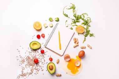 Notebook with healthy products on white background. Diet concept