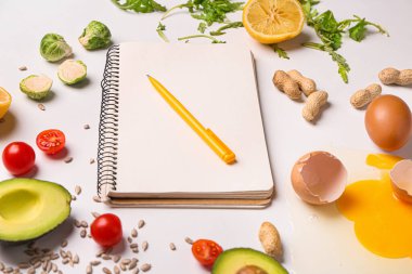 Notebook with healthy products on white background. Diet concept