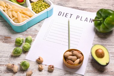 Sheet of paper with diet plan and healthy food on white wooden background