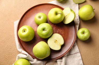 Plate with fresh ripe apples on color background