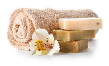 Towel, soap and flower on white background