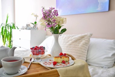 Tray table with tasty breakfast on bed