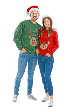 Beyaz arka planda Noel kıyafetleri içinde mutlu genç bir çift