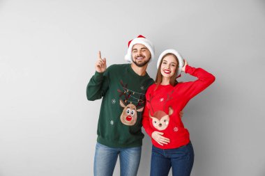 Işıklı arka planda Noel kıyafetleri içinde mutlu genç bir çift