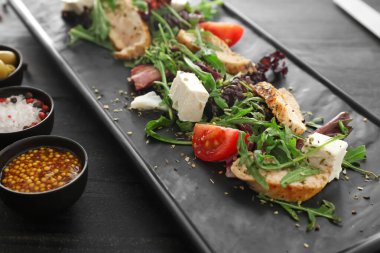 Koyu arkaplanda lezzetli salata tabağı, yakın plan.