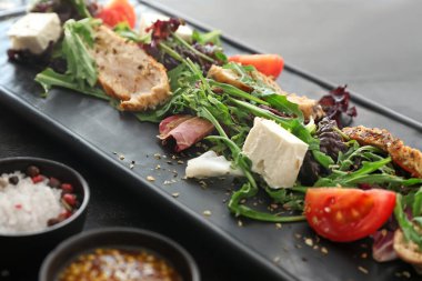 Koyu arkaplanda lezzetli salata tabağı, yakın plan.