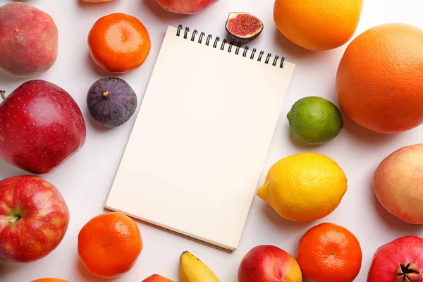 Notizbuch mit frischen Früchten auf weißem Hintergrund. Ernährungskonzept — Stockfoto