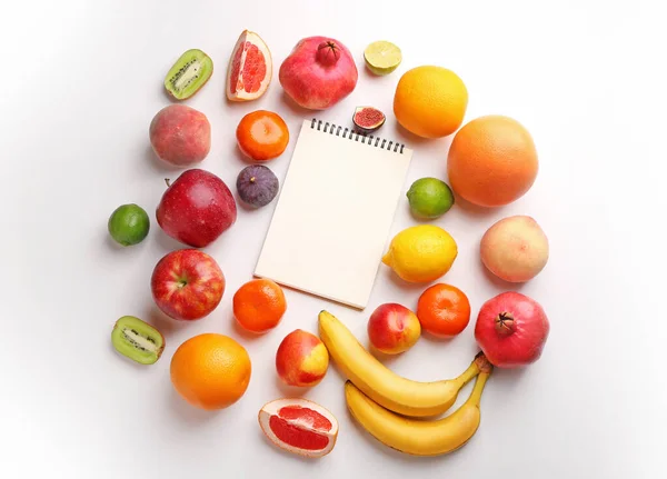 Notizbuch mit frischen Früchten auf weißem Hintergrund. Ernährungskonzept — Stockfoto