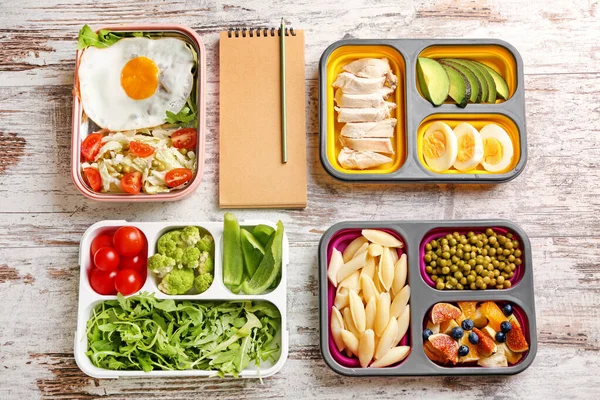 Notebook se zdravým jídlem v občerstvení boxy na bílém dřevěném pozadí. Dietní koncept — Stock fotografie