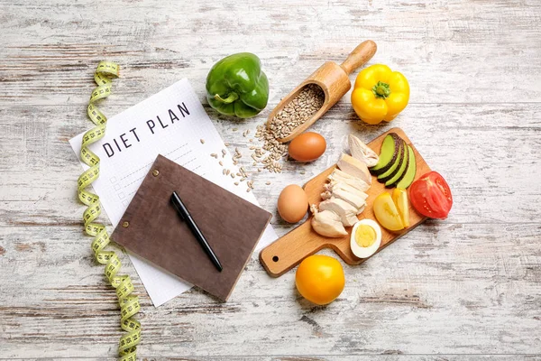 Blatt Papier mit Ernährungsplan, Maßband und gesunden Produkten auf weißem Holzgrund — Stockfoto