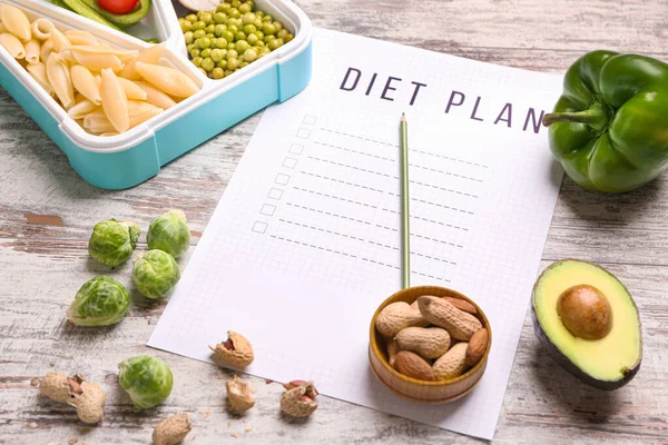 Blatt Papier mit Ernährungsplan und gesunder Ernährung auf weißem Holzgrund — Stockfoto