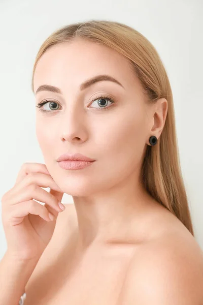 Portrait of beautiful young woman on light background — Stock Photo, Image