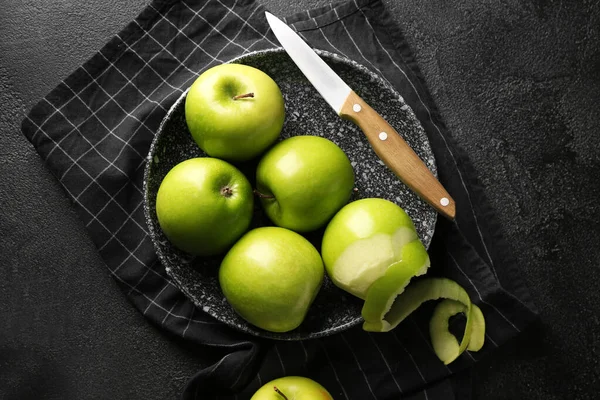 Plate with fresh ripe apples and knife on dark background — Stock Photo, Image