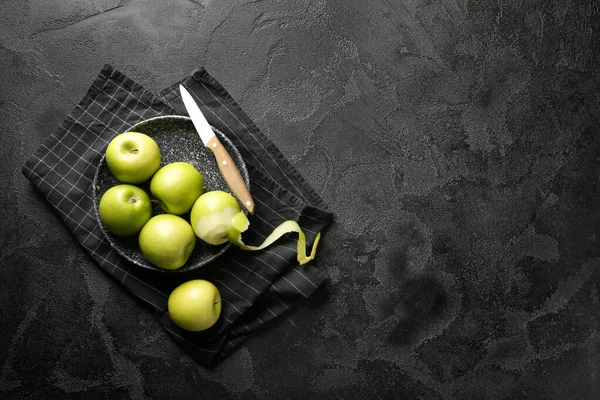 Plate with fresh ripe apples and knife on dark background — Stock Photo, Image