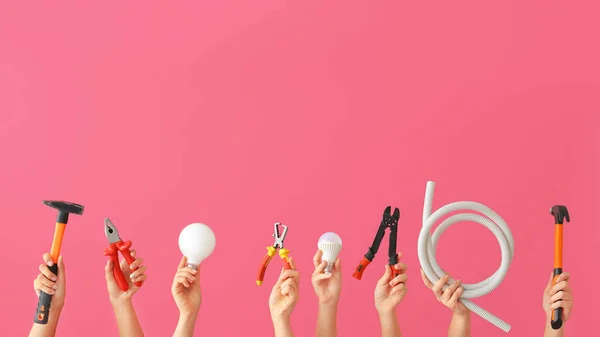 Mãos femininas com ferramentas de eletricista em fundo de cor — Fotografia de Stock