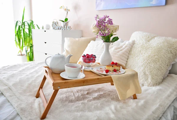 Tray table with tasty breakfast on bed — Stock Photo, Image