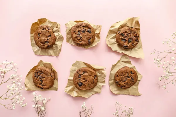 Biscoitos de chocolate saborosos e flores no fundo da cor — Fotografia de Stock