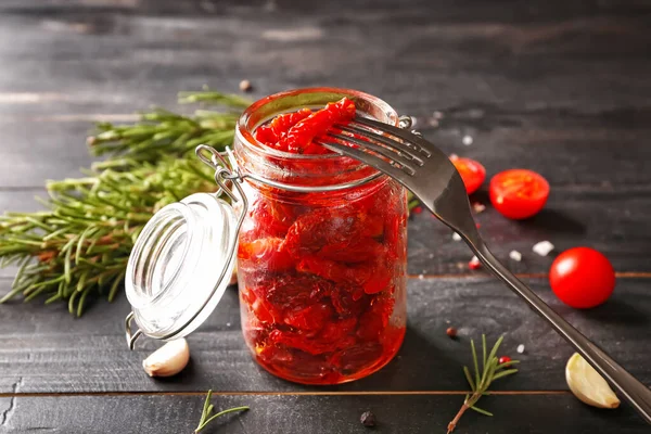 Jar with dried tomatoes and spices on table — Φωτογραφία Αρχείου