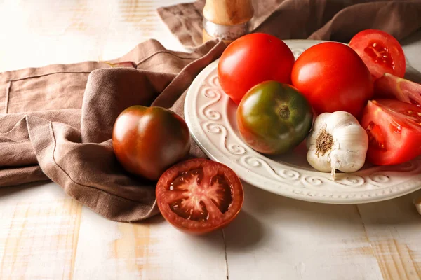 Plate with fresh tomatoes on wooden table — Zdjęcie stockowe