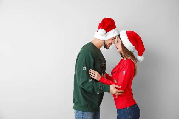 Feliz jovem casal em roupas de Natal no fundo de luz — Fotografia de Stock