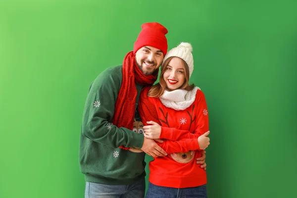 Feliz jovem casal em roupas de Natal no fundo de cor — Fotografia de Stock