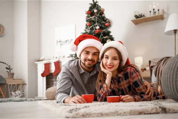 Feliz joven pareja celebrando la Navidad en casa — Foto de Stock