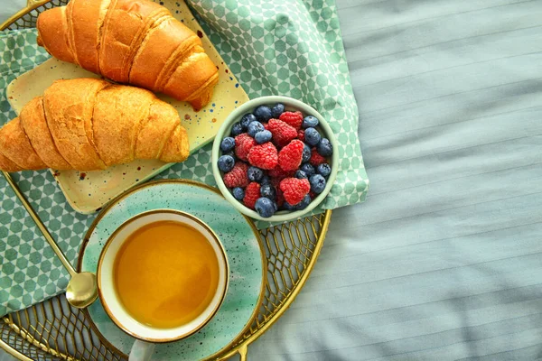 Tray with tasty breakfast on bed, top view — Stock Photo, Image