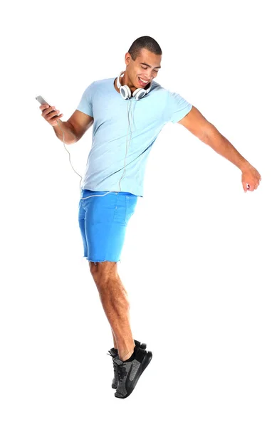 Retrato de jovem bonito com telefone celular e fones de ouvido dançando em fundo branco — Fotografia de Stock