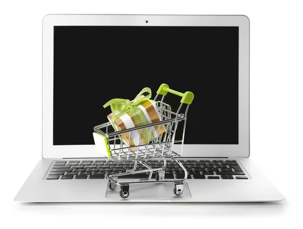 Laptop and small cart with gift on white background. Internet shopping concept — Stock Photo, Image