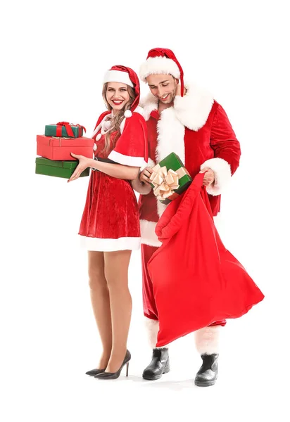 Young couple dressed as Santa Claus with Christmas gifts on white background — ストック写真