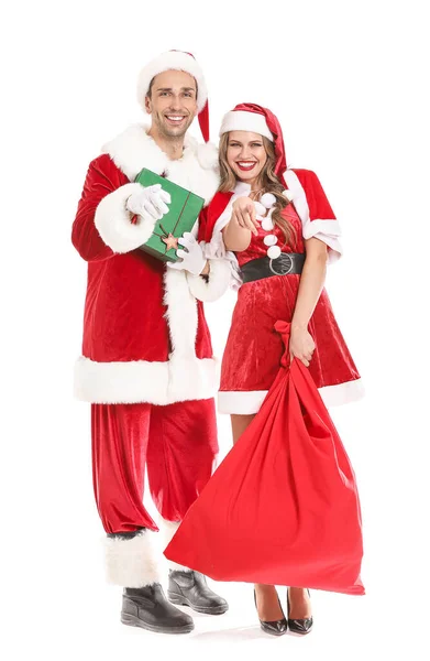 Young couple dressed as Santa Claus with Christmas gifts pointing at viewer on white background — ストック写真