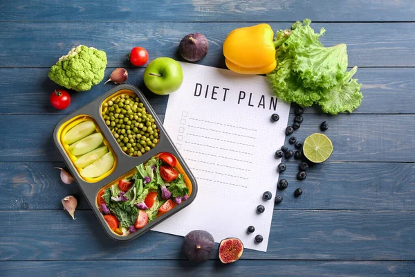 Sheet of paper with diet plan and healthy products on wooden table — Stock Image Sheet of paper with diet plan and healthy products on wooden table Royalty Free Stock Photos