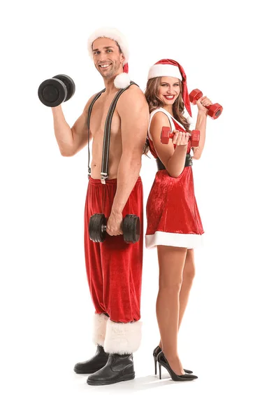 Young couple dressed as Santa Claus with dumbbells on white background — ストック写真