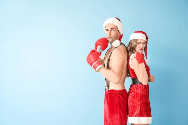 Young boxers dressed as Santa Claus on color background — Stock Photo, Image