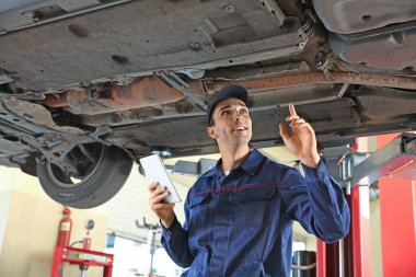 Araç hizmet merkezinde tablet bilgisayarlı erkek tamirci