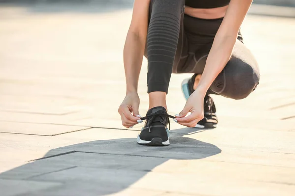 Sporty giovane donna allacciatura lacci delle scarpe all'aperto — Foto Stock