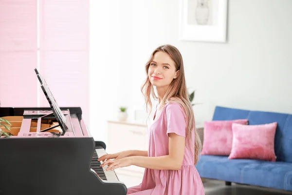 집에서 그랜드 피아노를 연주하는 젊은 여자 — 스톡 사진