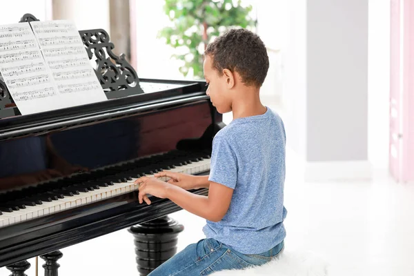 Piccolo ragazzo afroamericano che suona il pianoforte a coda a casa — Foto Stock
