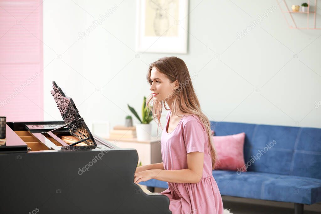 Young woman playing grand piano at home