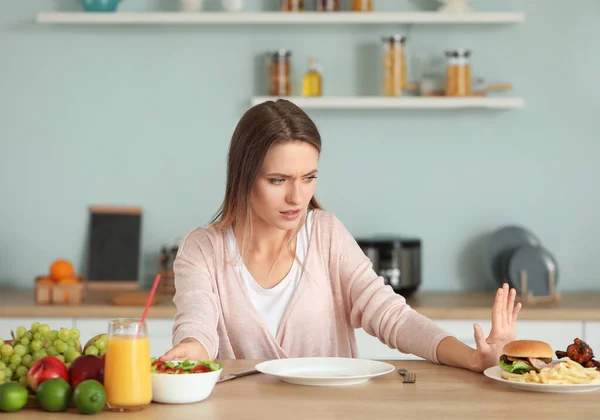 Mujer que se niega a comer alimentos poco saludables en la cocina. Concepto de dieta —  Fotos de Stock