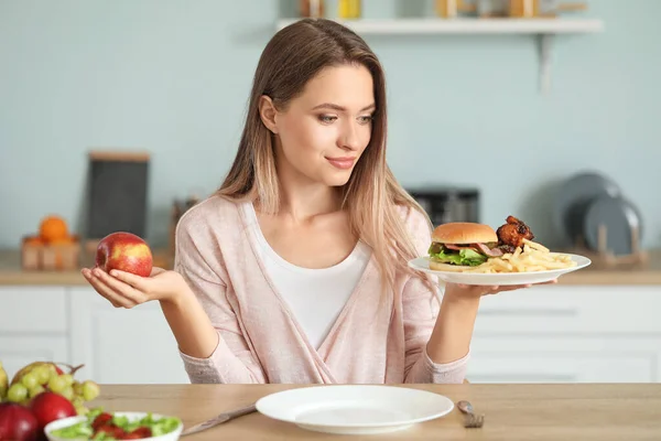 キッチンで健康的で不健康な食べ物の間で選択する女性。国会の概念 — ストック写真