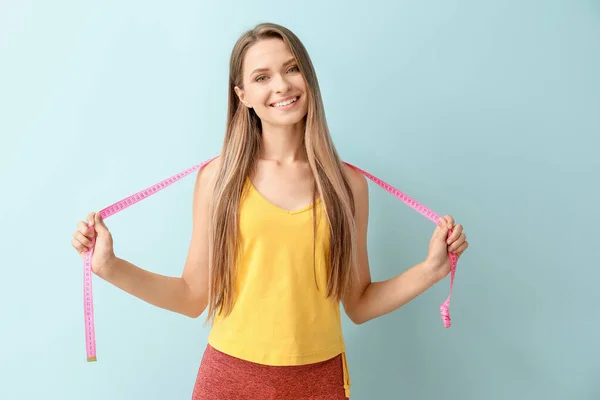 Šťastná žena s měřicí páskou na světlém pozadí. Dietní koncept — Stock fotografie
