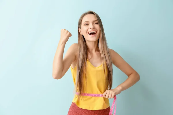 Happy woman with measuring tape on light background. Diet concept — Stock Photo, Image