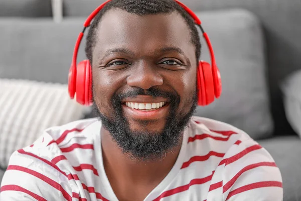 Handsome African-American man listening to music at home — Stock Photo, Image