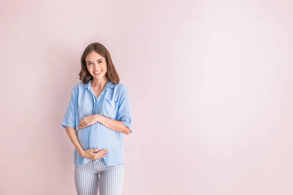 Mooie zwangere vrouw op lichte achtergrond — Stockfoto