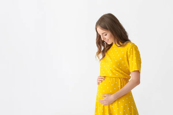 Hermosa mujer embarazada sobre fondo claro — Foto de Stock