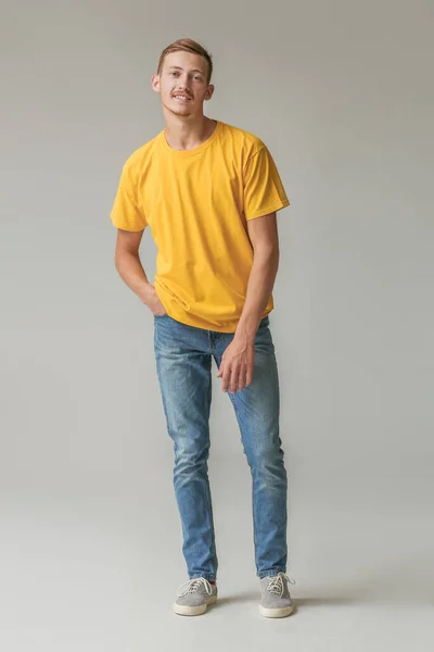 Young man in stylish t-shirt on grey background — Stock Photo, Image